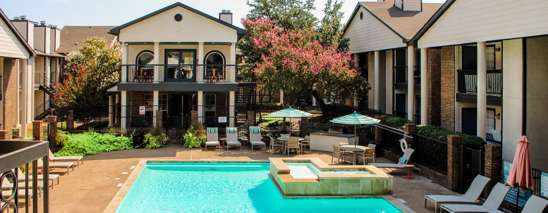 a swimming pool with lounge chairs in a courtyard